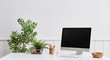 © UnitedPhotoStudio - Computer and desktop on the table. vase of plant background. white wall.