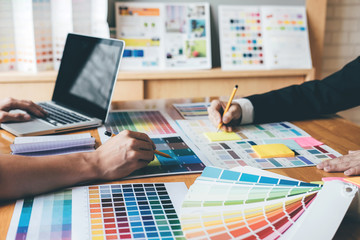 Young creative team having a meeting in creative office, Architectural drawing with work tools and accessories, Color swatch samples chart for selection coloring