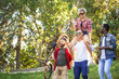 © alfa27 - Multi-ethnic group of people going with their male friend to bmx contest in the urban summer park, Young cheerful man giving piggyback ride to his blonde girlfriend. Fun and Bonding Concept.