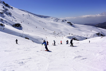 Esquiadores montando desde las cimas de la sierra nevada.