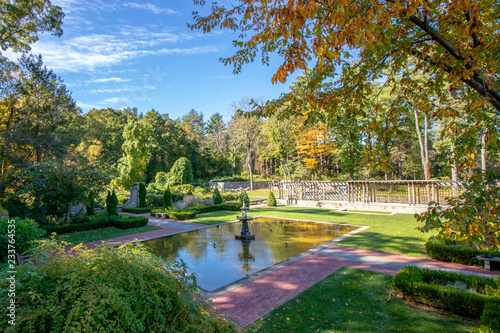 Fotografie, Obraz view of small man made pond with statue and landscaped area