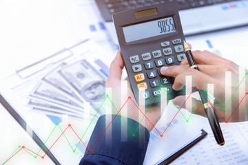 Businessman's hands with calculator at the office and Financial data analyzing counting on desk in office.