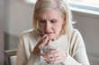 © fizkes - Senior lady suffering from pain or headache doubt about taking painkiller pill, upset aged woman have antibiotics or prescribed medicines, elderly lady with depression hold antidepressant and water