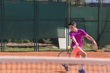 Young tennis player hitting the ball