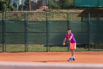 Young tennis player serving the ball