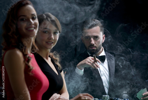 Photographie Upper class friends gambling in a casino.
