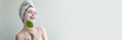 © Юлия Завалишина - Beauty portrait of woman in towel on head with white nourishing mask or creme on face and green leaf in hand, white background isolated. Skincare cleansing eco organic cosmetic spa concept Banner