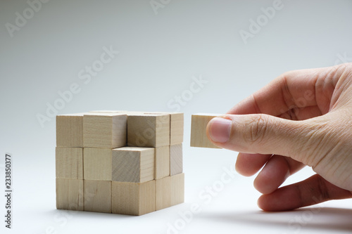 Fotografía Hand to complete last piece wood cube for a bigger block