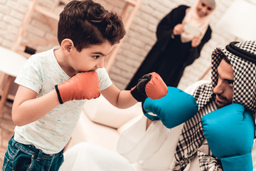 Wall Mural - Arabian Boy Boxing with Young Father at Home.