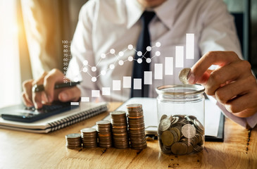 businessman holding coins putting in glass with using smartphone and calculator to calculate  concept saving money for finance accounting