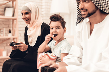 Wall Mural - Happy Arabian Family Playing on Console at Home.