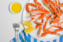 Plate With Crab Legs, Forks And Lemon  On White From Above