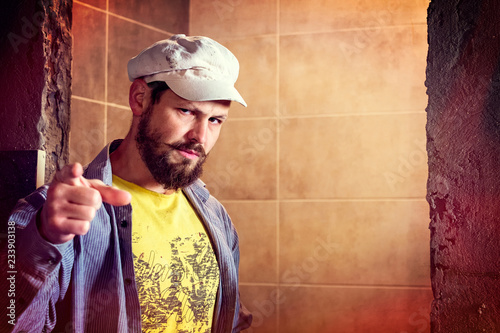 Fotomural Brutal bearded man in a eight-blade cap indignantly frowned, pointing his finger
