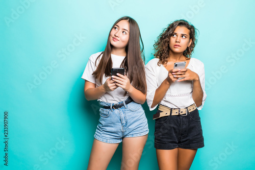 Fotografia Photo of curious african american woman peeking at mobile phone of asian girl in