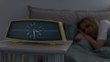 © DimaBerlin - Closeup of vintage alarm clock on bedside table and calm young caucasian woman sleeping in bed, selective focus. Oversleep, healthy sleep, deep dream concept