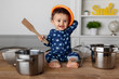 © Lisa Tichané - Happy baby playing drums with utensils on kitchen table