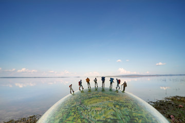 miniature figure people backpack miniature figure people backpack standing on globe with blue sky ba