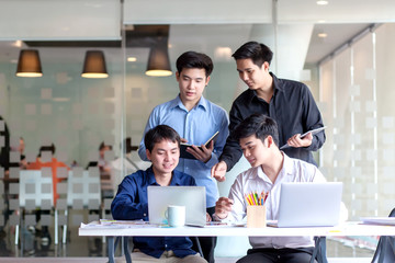 Groups of young men who talking together to discuss the work in the workplace.