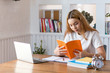© amnaj - Asian female student sitting reading in the library.