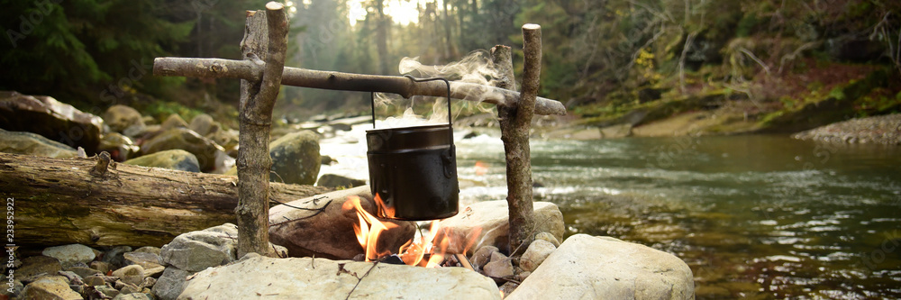 Cooking food in pot over campfire outdoor - obrazy, fototapety, plakaty 