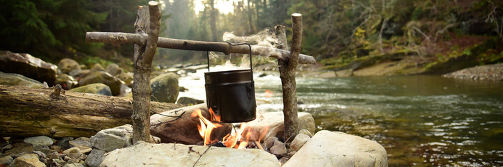 cooking food in pot over campfire outdoor