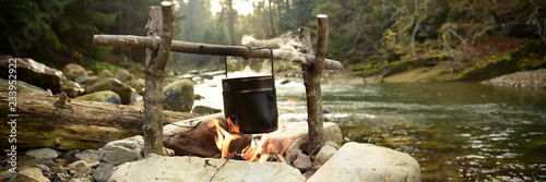 Fotomural Cooking food in pot over campfire outdoor