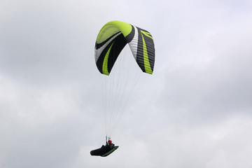 Paraglider flying wing in a cloudy sky