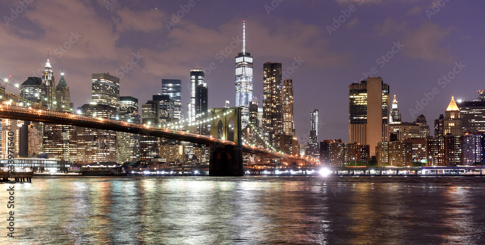 New York City, financial district in lower Manhattan with Brooklin Bridge at night, USA - obrazy, fototapety, plakaty 