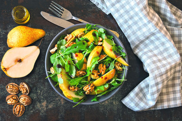 Healthy food bowl. Salad with arugula, pear and walnut. Vegan bowl of colorful salad.