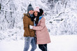 © gorynvd - Beautiful pregnant woman dressed in warm clothes walking with her lovely husband in snowy winter park.