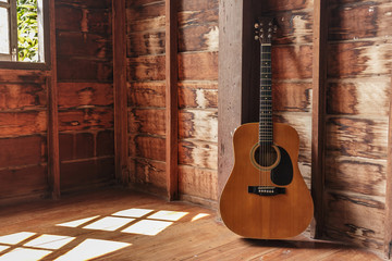 Old guitar classic in room on wall wooden.