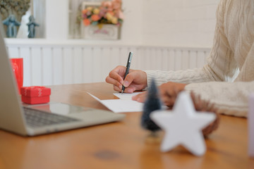 man writing christmas letter greeting card holiday wishes with xmas decoration