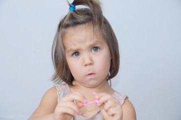 Wall Mural - Surprised and disconcerted little girl portrait. child funny face with expressive emotion. emotional toddler frightened at gray background.