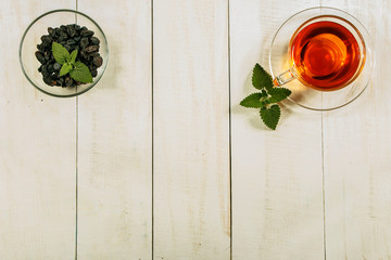 A cup of tea on a white table.Traditional Arabic, Turkish Ramadan tea with dry dates and raisins on a wooden white table. Turkish fresh tea with dates. Ramadan kareem. Ramadan background mock up.