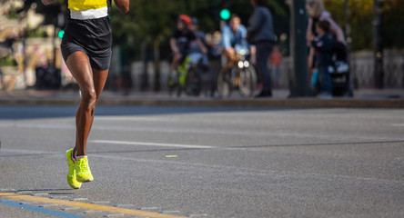 Wall Mural - Running in the city roads. Young woman runner, front view, banner, blur background