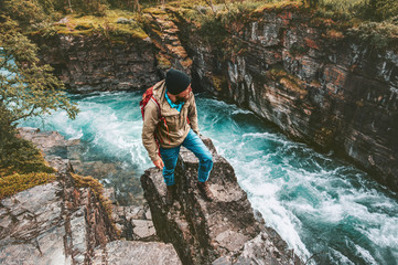 Wall Mural - Adventurer man hiking alone active lifestyle extreme vacations outdoor on cliff above river canyon in Sweden