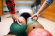 Two male bowlers takes balls from feeder