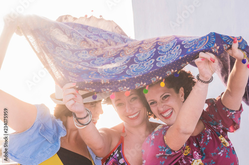 Fotografie, Obraz three young women have fun together playing with the wind and laughing a lot hav