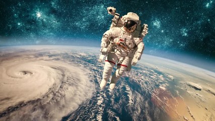 Wall Mural - astronaut in outer space against the backdrop of the planet earth. typhoon over planet earth. elemen