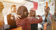 Businesswomen hugging while brainstorming with their team in an