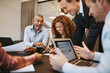 Diverse businesspeople laughing during a meeting together in an