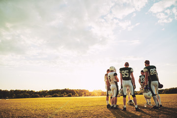 American football team discussing strategy together during pract