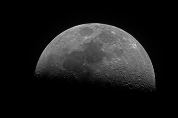 Wall Mural - horizontal big and bright moon in its first quarter phase, isolated in dark background into space, t