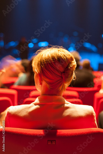 Fotomural Jeune femme blondede dos assise dans salle de spectacle