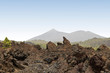 Vulkanische Landschaft mit alten Lavaflüssen und Vulkan im Hinergrund