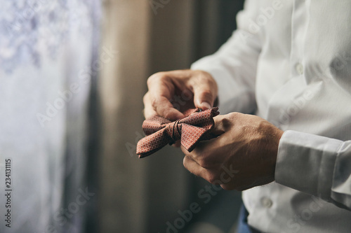 Fotografía businessman putting on bow tie,man butterfly clothes,groom getting ready in the