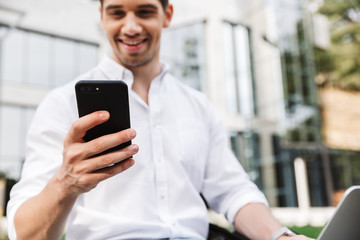 Wall Mural - Happy young business man using mobile phone