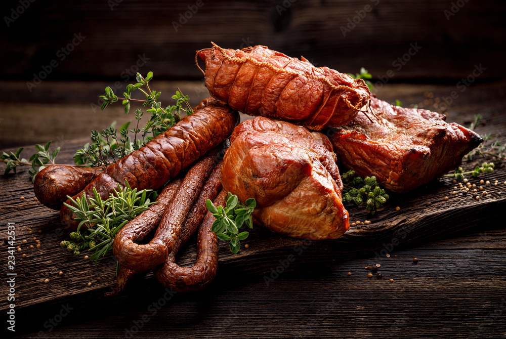 Smoked meats and sausages. A set of traditional smoked meats and sausages: ham,gammon, pork loin, home-style sausages, kabanosy. Traditional meats and sausages smoked in apple, beech and juniper wood  - obrazy, fototapety, plakaty 