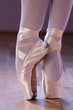 Feet dressing a pair of pointe shoes