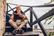 © maryviolet - College student with backpack reading book walking in autumn park sitting on stairs